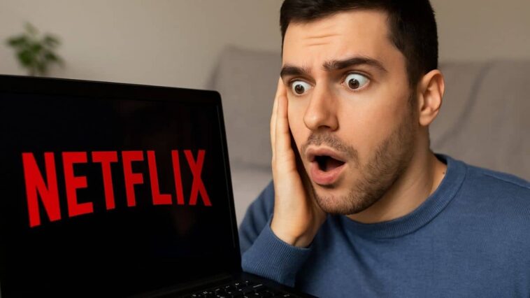 Un jeune homme surpris découvre la nouvelle interface Netflix sur son ordinateur portable.
